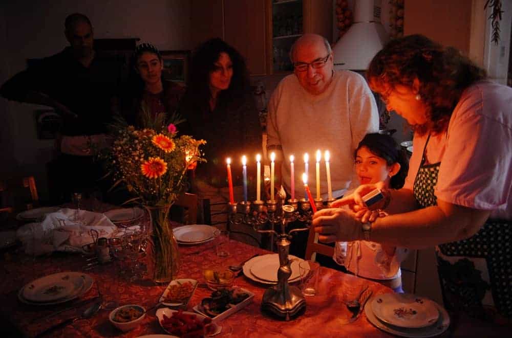 rodzina zapala świece na chanukę