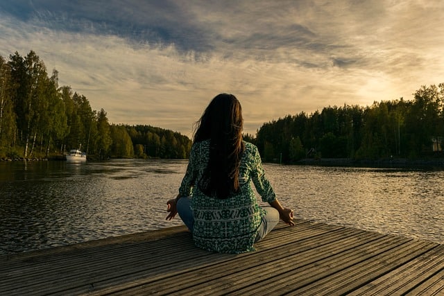 kobieta na brzegiem jeziora uprawia manifestacje duchowa